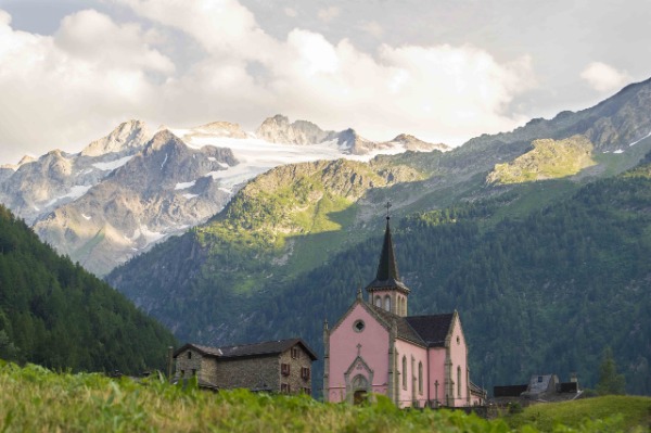 Pequena igreja no meio da montanha com casa de madeira