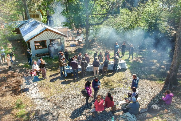 Um grupo de pessoas saboreando alimentos em um abrigo no meio da floresta.