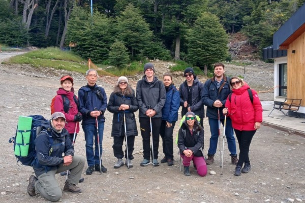 Grupo equipado posando no início da trilha de trekking da geleira marcial