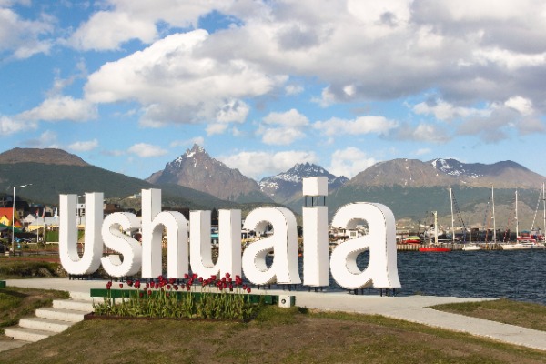 Pôster de Ushuaia ao lado do porto com navios atracados