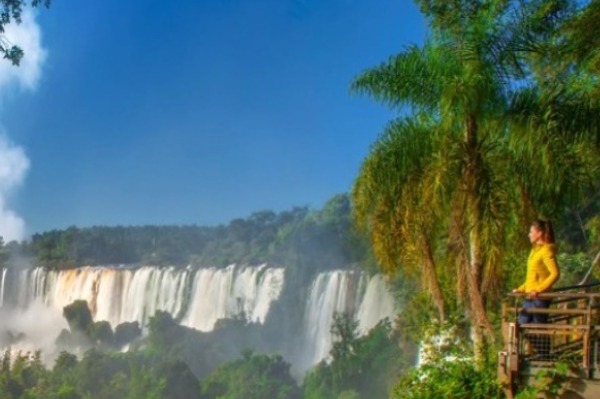 Mulher passarela Cataratas Iguaçu lado brasileiro. Mulher sobre a passarela admirando as Cataratas do Iguaçu pelo lado brasileiro.