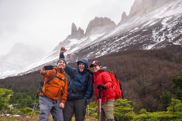 Grupo de caminhantes posando em frente às Torres del Paine no inverno.