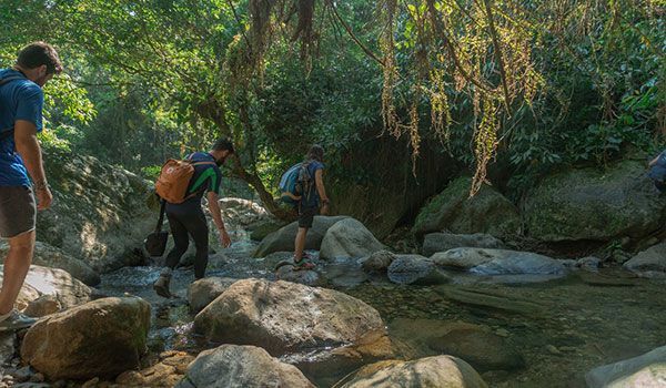 Caminhada na Cidade Perdida 3 dias Colômbia Caminhantes cruzando um rio durante a caminhada de três dias em Ciudad Perdida, na Colômbia.
