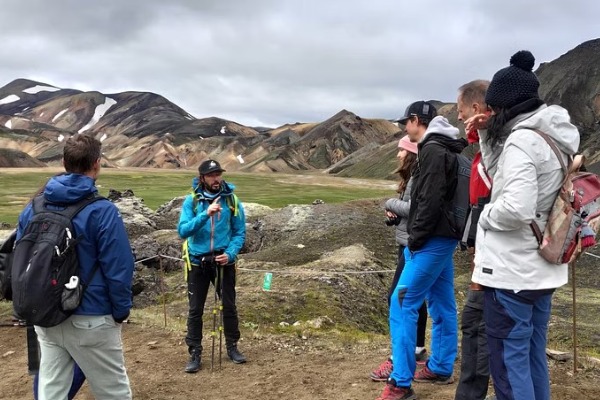 Guia explicando aos turistas o cenário colorido das montanhas