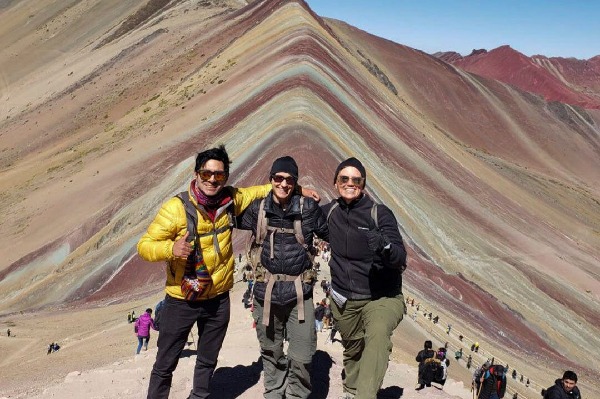 pessoas posando em frente à montanha das 7 cores