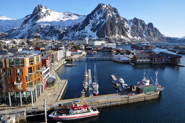 Anlegestelle Svolvær Panoramablick auf den Kai von Svolvær mit Schiffen und schneebedeckten Bergen im Hintergrund