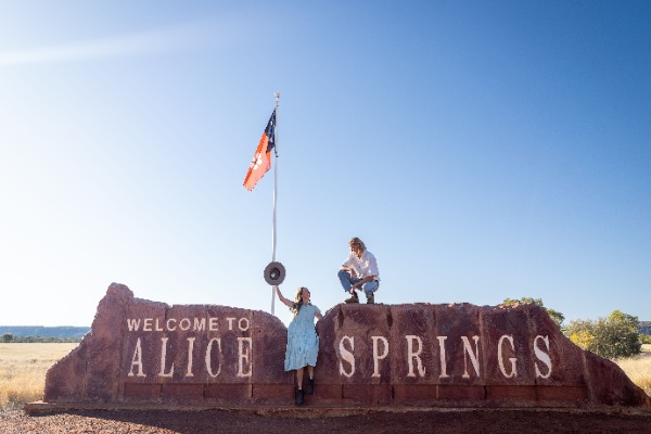 Reisende Frauen, Eingang zu Alice Springs Reisende auf einem Plakat am Ortseingang von Alice Springs