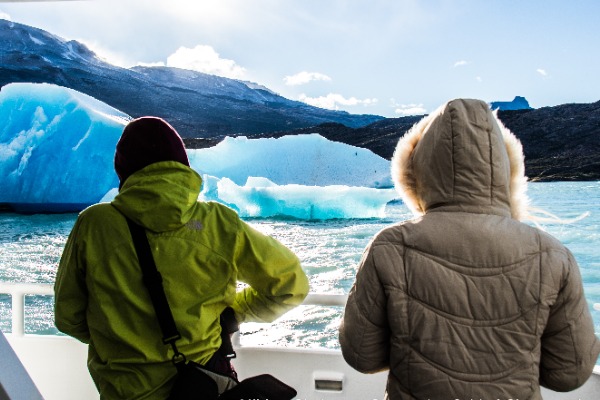 Blick auf einen treibenden Eisberg Menschen fotografieren von hinten einen Eisberg während der Bootsfahrt