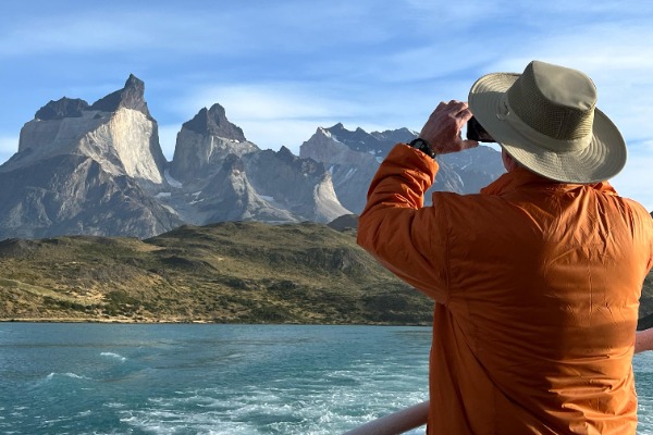 Mann beim Fotografieren und Segeln auf dem Katamaran