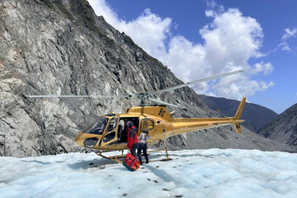 Reisende besteigen den Helikopter, der vom Fox Glacier zurückkehrt