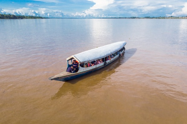 Schifffahrt auf dem Amazonas Holzboot mit Menschen, die auf dem Amazonas schippern