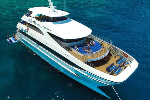 Evolution Superyacht - Reef Fleet Aerial view of the luxury superyacht Evolution cruising on turquoise water during a Great Barrier Reef snorkeling tour from Cairns.