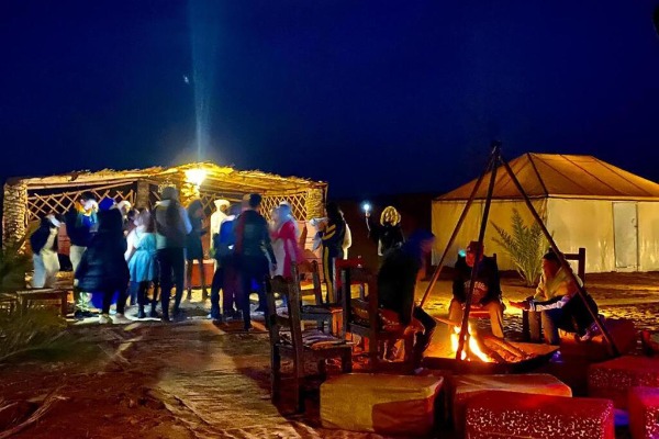A Berber Night at the Merzouga Glamping Site Travelers gathered around the bonfire during an evening of Berber music at the Merzouga glamping site