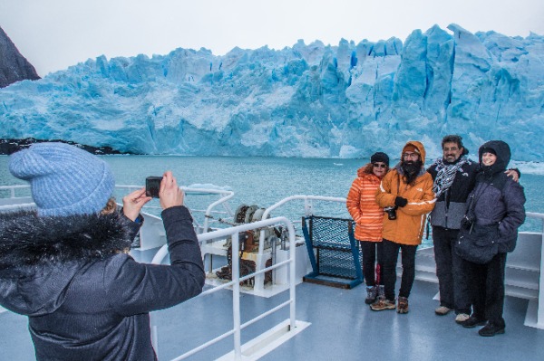 tourists taking photos from the boat in front of Perito Moreno