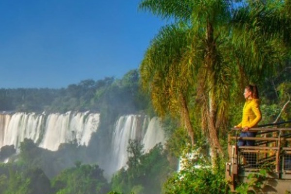 Woman observes the Iguassu Falls from the Brazilian side from a footbridge