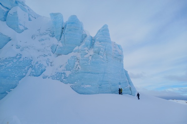 people exploring the area next to the Ojo del Albino Glacier.