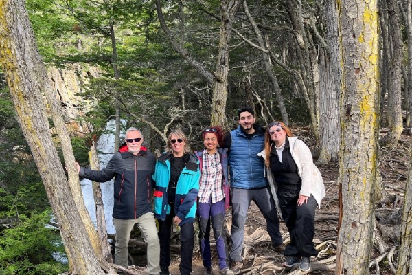 people among trees posing in front of the waterfall bridal veil