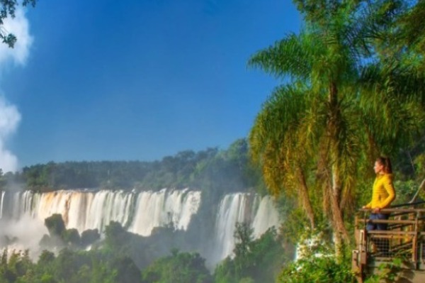 Woman on walkway admiring Iguazu Falls from the Brazilian side