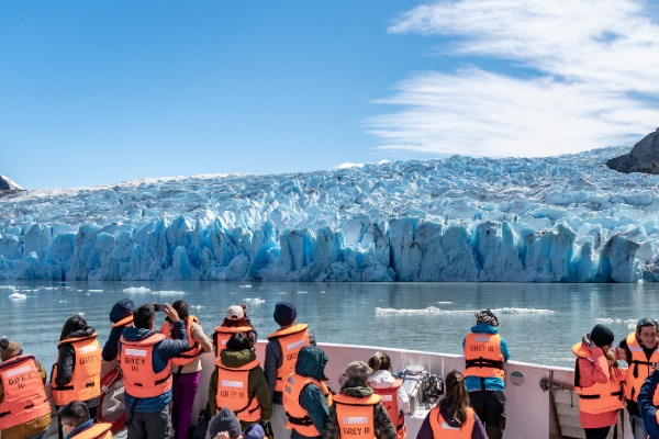 group in the boat in front of the glacier grey