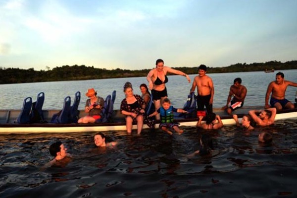 Travelers enjoy a stroll along Laguna Grande at sunset in Cuyabeno