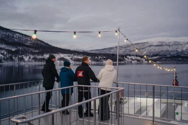 people with the guide on the deck of the boat observing marine fauna