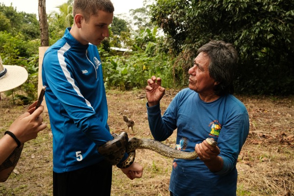 Local guide showing a snake to travelers during a Pacaya Samiria tour activity.