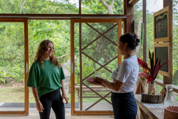 Ecolodge staff giving a welcome drink to a traveler at Amazon lodge in Tambopata, Puerto Maldonado.