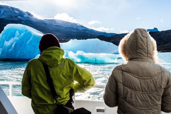 personas de espaldas fotografiando iceberg durante navegacion