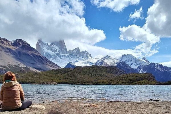 Vistas al Fitz Roy desde el Mirador Laguna Capri Persona sentada frente a la Laguna Capri con el cerro Fitz Roy al fondo en un día parcialmente nublado