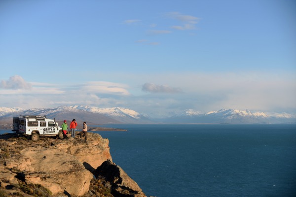 personas observando el lago argentino desde el acantilado