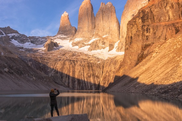 Viajero contemplando las Torres del Paine reflejadas en la laguna del mirador Base