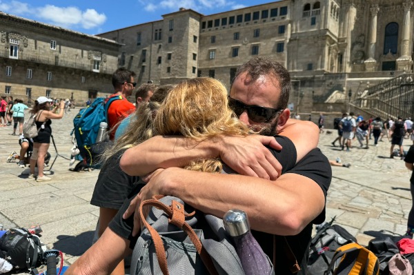 Llegada a Santiago de Compostela tras completar el Camino Peregrinos abrazándose en la Plaza del Obradoiro tras completar el Camino Francés desde Sarria