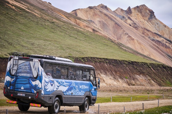 Minivan de espaldas por carretera en mitad de montañas