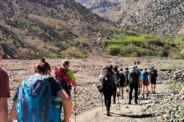 Trekking por el Alto Atlas en Marruecos Grupo de senderistas caminando por un valle de montaña durante un trekking por el Alto Atlas en Marruecos.