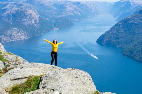 mujer en la cima del Preikestolen mujer de amarillo en la cima del Preikestolen