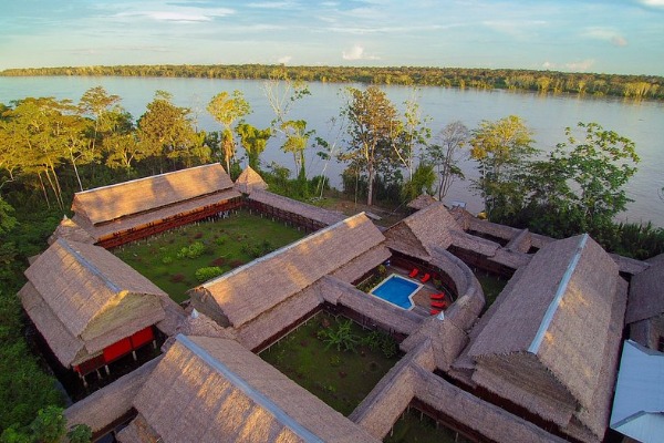 Lodge de lujo en la selva de Iquitos frente al Amazonas Vista aérea de lodge amazónico con piscina junto al río Amazonas en Iquitos
