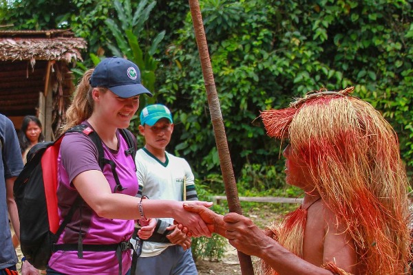 Encuentro con la comunidad indígena Yagua Turista estrechando la mano a un miembro de la comunidad Yagua en la Amazonía