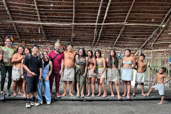 Encuentro cultural con una tribu nativa grupo de personas posando para la foto con la tribu cultural nativa de la selva