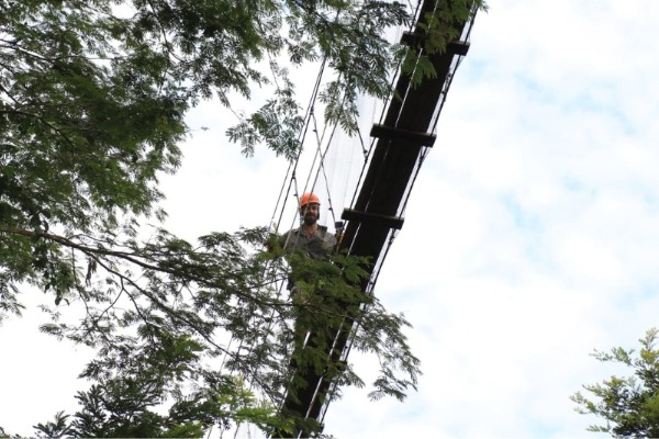 puente colgante en la selva de Iquitos persona con casco de seguridad cruzando el puente colgante en la selva de iquitos