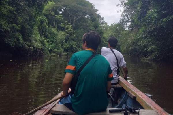 Navegación por el río Marañón dos personas en una embarcacion de madera navegando por el rio marañón