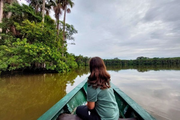 Viajera navegando por el Lago Sandoval rodeado de selva tropical durante la excursión desde Puerto Maldonado
