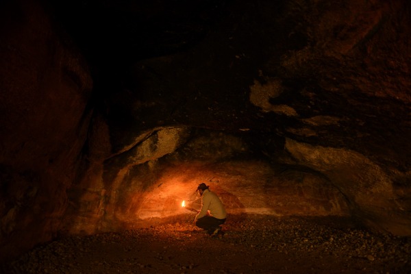 guide montrant les peintures rupestres de la grotte