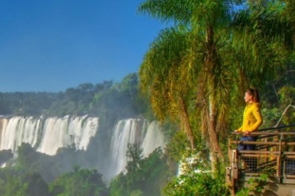 Une femme observe le côté brésilien des chutes d'Iguazu depuis une passerelle.