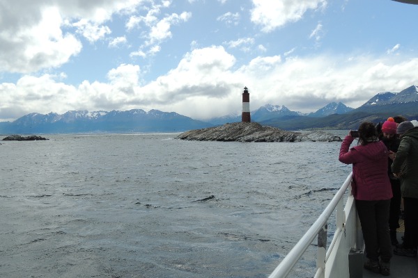 Des voyageurs devant le phare Des voyageurs prenant des photos du phare depuis le bateau