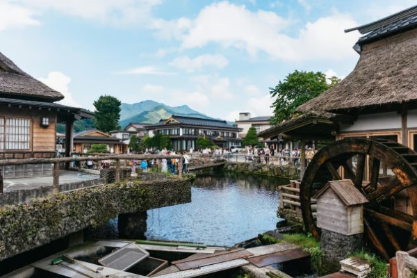Roue à eau et maisons en paille à Oshino Hakkai lors de l'excursion au mont Fuji au départ de Tokyo Un moulin à eau en bois et des maisons traditionnelles au toit de chaume près de l'étang d'Oshino Hakkai.