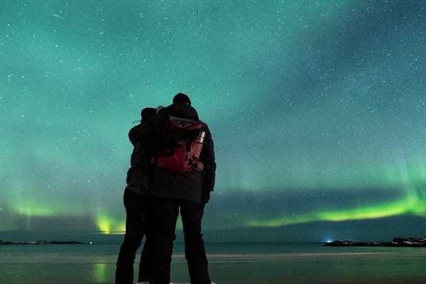 couple s'embrassant avec des aurores en arrière-plan un couple s'embrassant avec des aurores en arrière-plan
