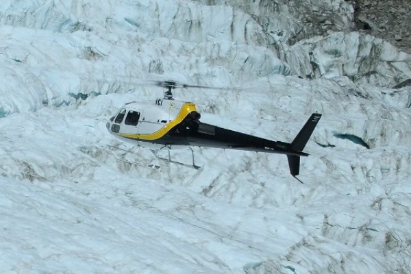 Un hélicoptère survole le glacier Fox
