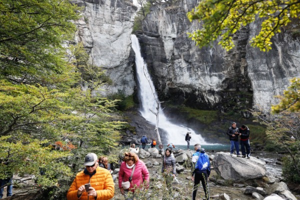 trekking del corno del capo cascata sullo sfondo con turisti che fanno trekking