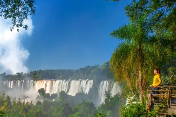 Donna osserva il lato brasiliano delle cascate di Iguazu da un ponte pedonale
