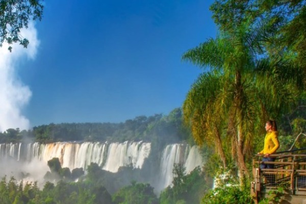 donna iguazú cade lato brasiliano Donna osserva il lato brasiliano delle cascate di Iguazu da un ponte pedonale